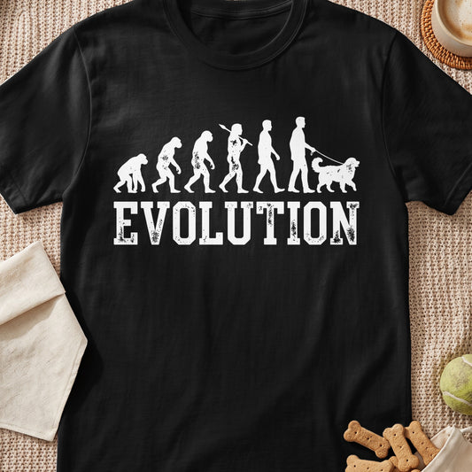 Black t-shirt with white graphic of human evolution ending with person walking a dog.