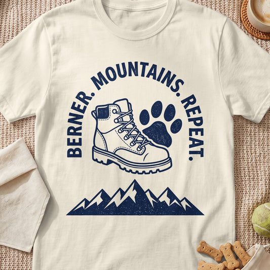 Berner. Mountains. Repeat. graphic on cream t-shirt with hiking boot and paw print.