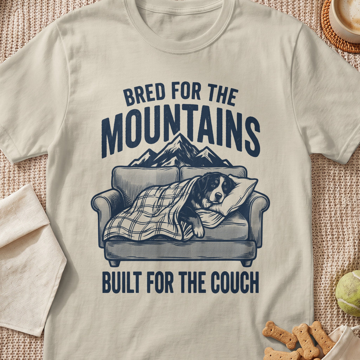 T-shirt graphic with text "Bred for the mountains" and a dog sleeping on a couch.