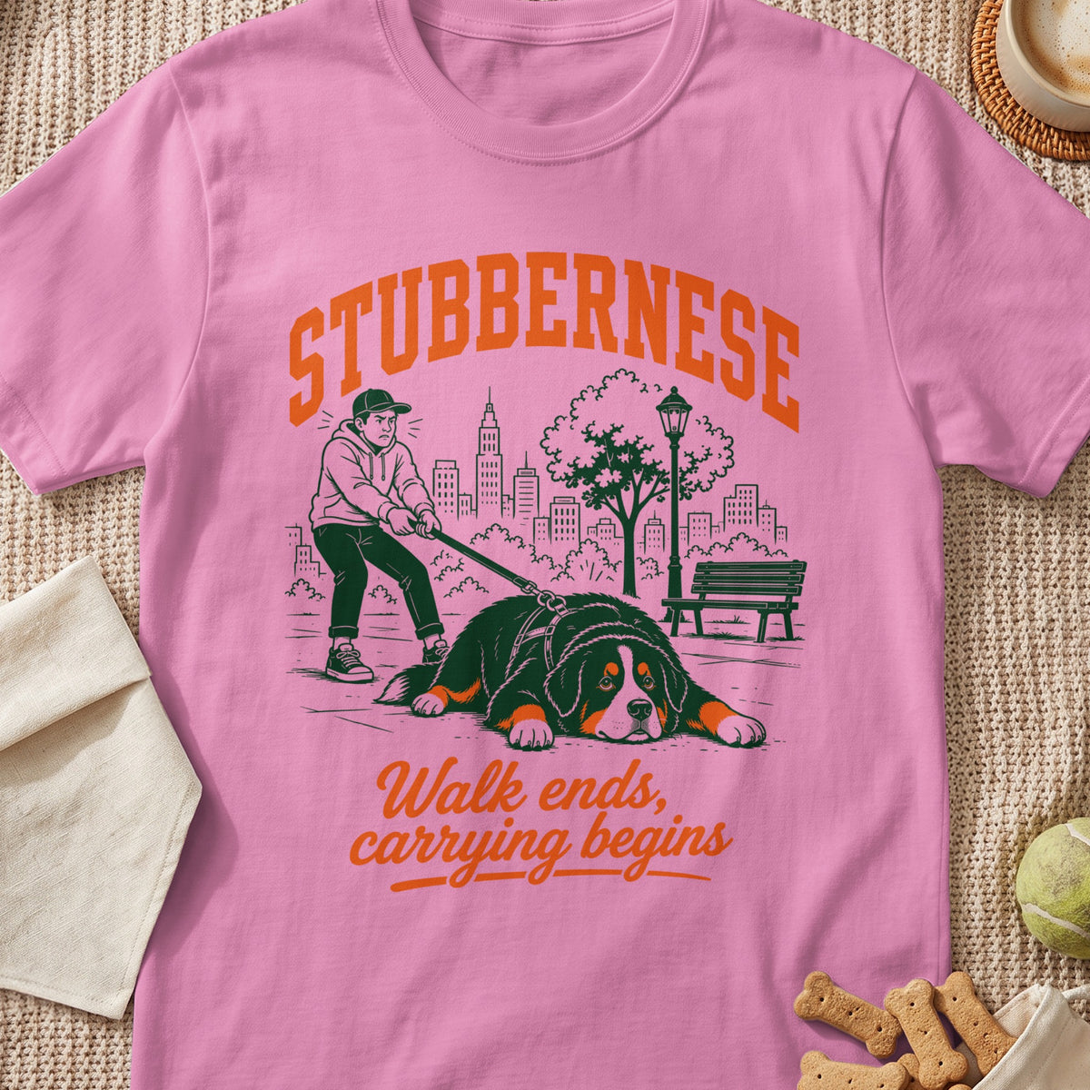 Pink t-shirt with "STUBBERNESE" text and illustration of person walking a large dog.