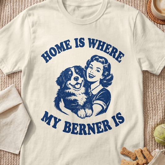 Cream t-shirt with blue text "HOME IS WHERE MY BERNER IS" and illustration of woman holding Bernese Mountain Dog.
