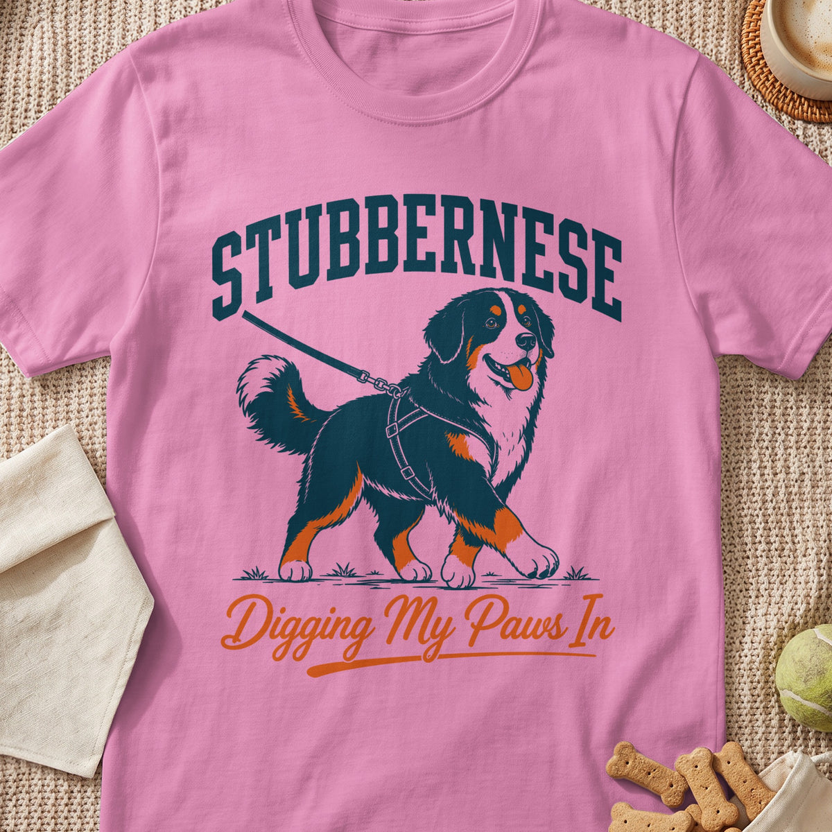 Pink t-shirt with a Bernese Mountain Dog graphic and text "STUBBERNESE Digging My Paws In".