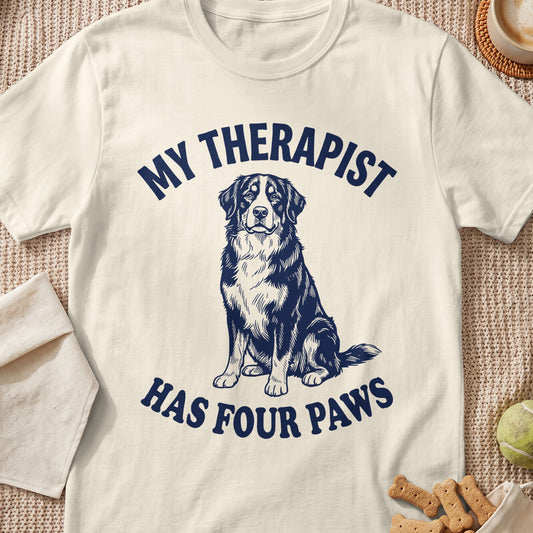 Cream t-shirt with navy text "MY THERAPIST HAS FOUR PAWS" and a dog graphic.