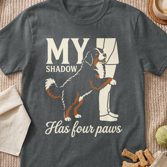 "My Shadow Has Four Paws" text with Bernese Mountain Dog at a person's leg.