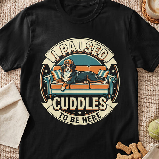 Bernese Mountain Dog wearing sunglasses and cap on a couch, text "I Paused Cuddles To Be Here".