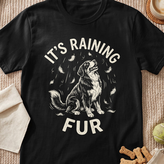 Black t-shirt with a dog looking up at falling feathers and text "It's Raining Fur".
