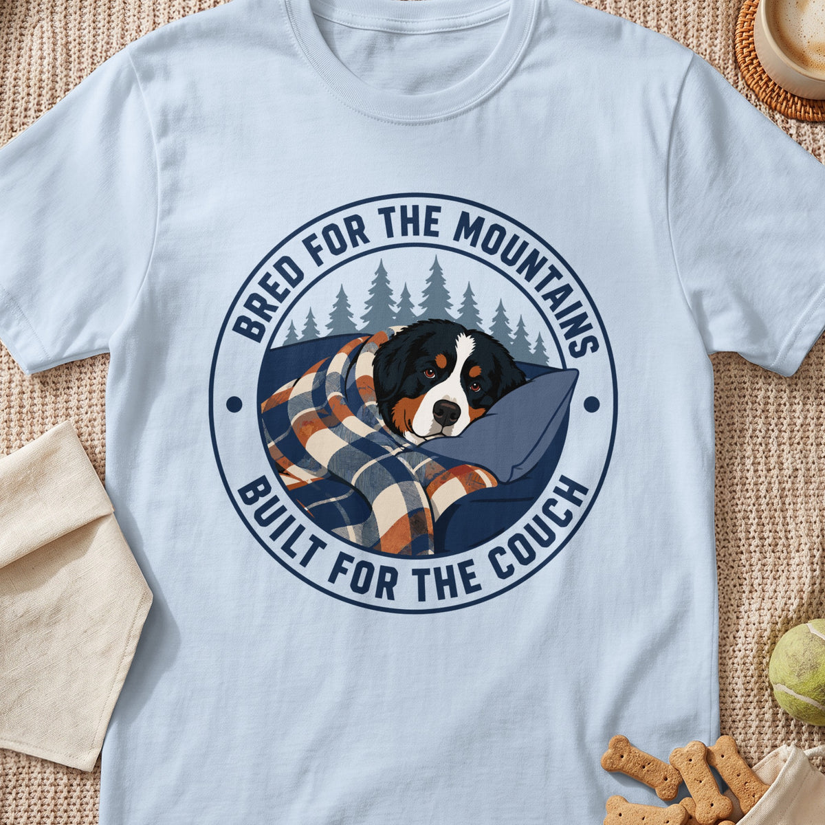 Bernese Mountain Dog wrapped in a blanket with trees, text "Bred for the Mountains, Built for the Couch".