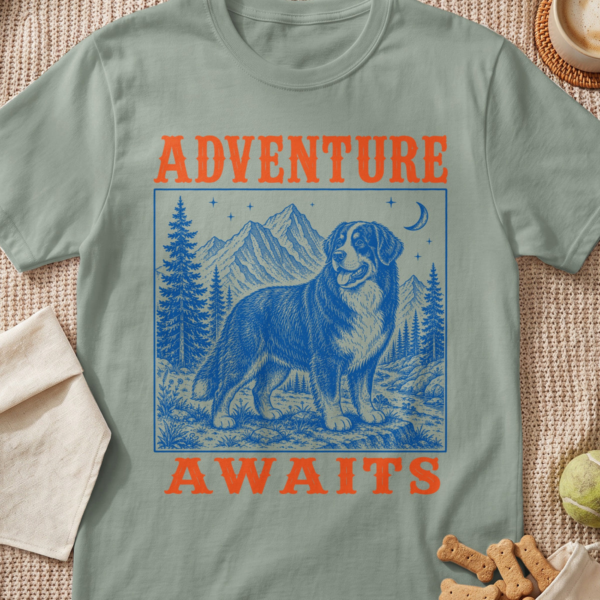 Green t-shirt with "ADVENTURE WAITS" and a blue illustration of a Bernese Mountain Dog in a landscape.