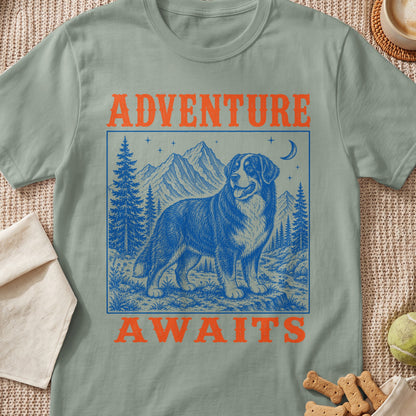 Green t-shirt with "ADVENTURE WAITS" and a blue illustration of a Bernese Mountain Dog in a landscape.