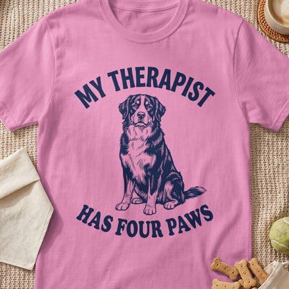 Pink t-shirt with navy text "MY THERAPIST HAS FOUR PAWS" and dog illustration.