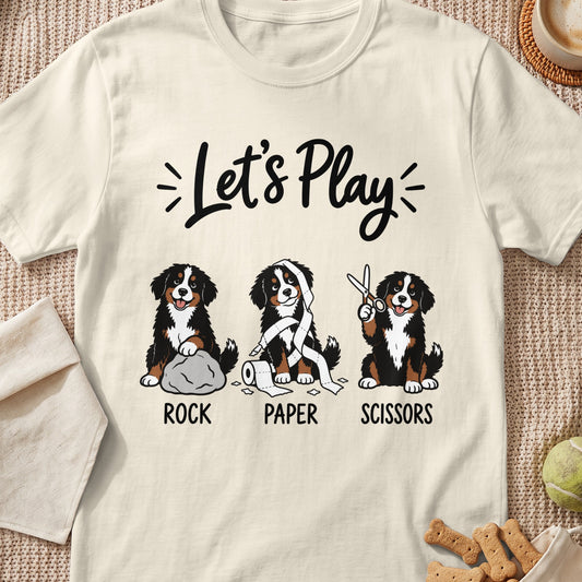 Three Bernese Mountain Dogs play rock, paper, scissors, with text Let's Play.