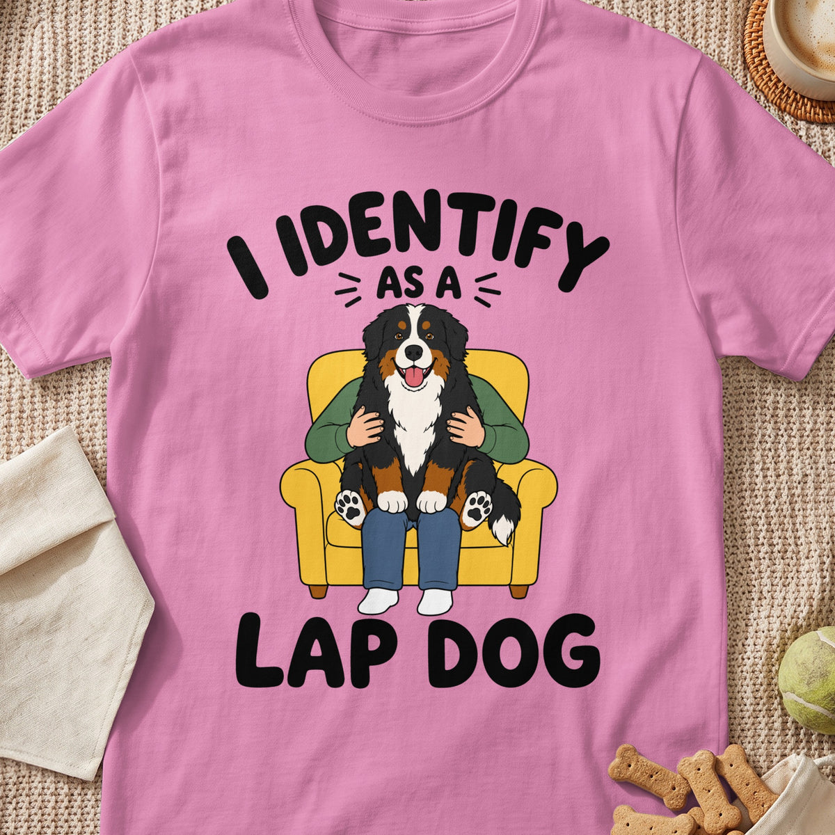 Pink t-shirt with cartoon of Bernese Mountain Dog on lap that reads "I identify as a lap dog."