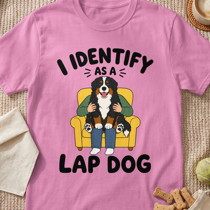 Pink t-shirt with cartoon of Bernese Mountain Dog on lap that reads "I identify as a lap dog."
