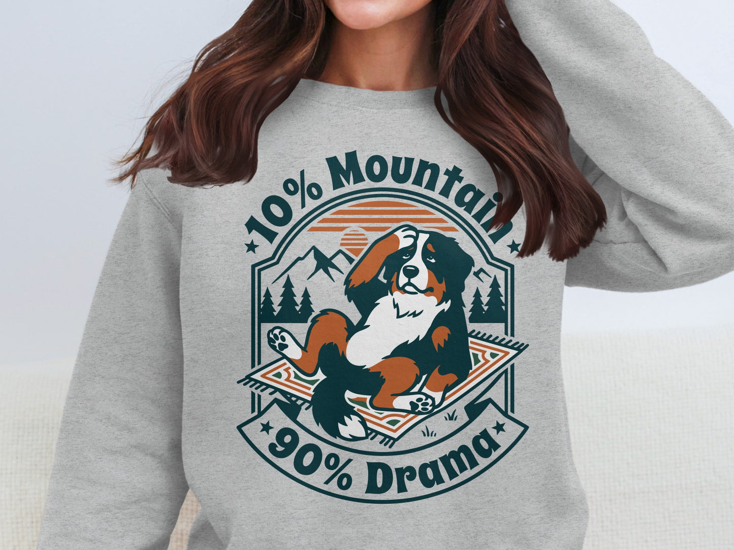 Bernese mountain dog lounging on a rug with mountains and text "10% Mountain 90% Drama".