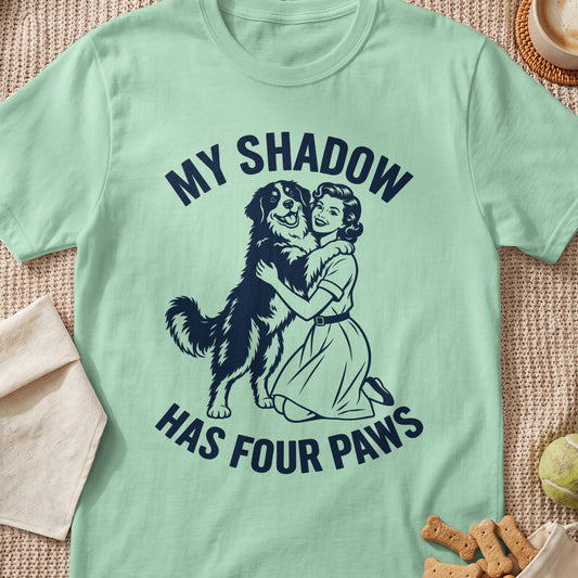 Mint green t-shirt with "My Shadow Has Four Paws" text and a woman hugging a dog.