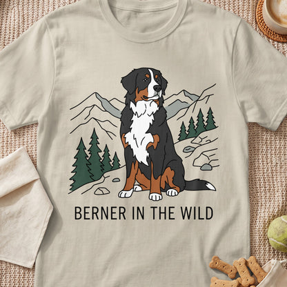 Bernese Mountain Dog sits in a stylized mountain landscape with text "BERNER IN THE WILD."