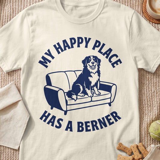 Cream t-shirt with navy graphic of a Bernese Mountain Dog on a couch, text reads "My Happy Place Has a Berner".
