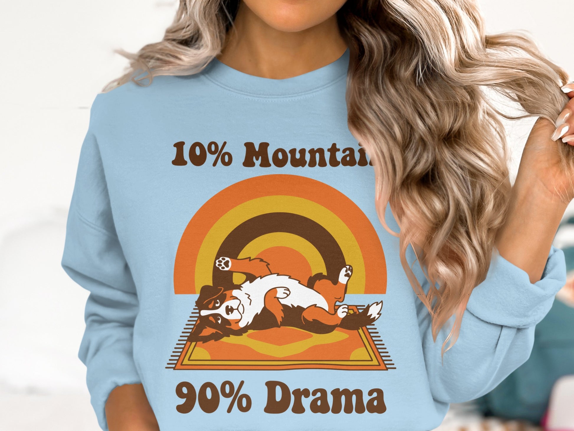 Light blue sweatshirt with "10% Mountain 90% Drama" text and a dog on a rug.