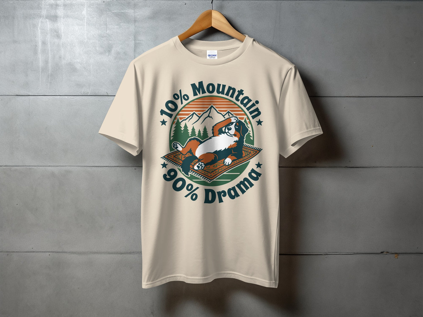 Cream t-shirt with graphic stating "10% Mountain, 90% Drama" and a relaxing dog.