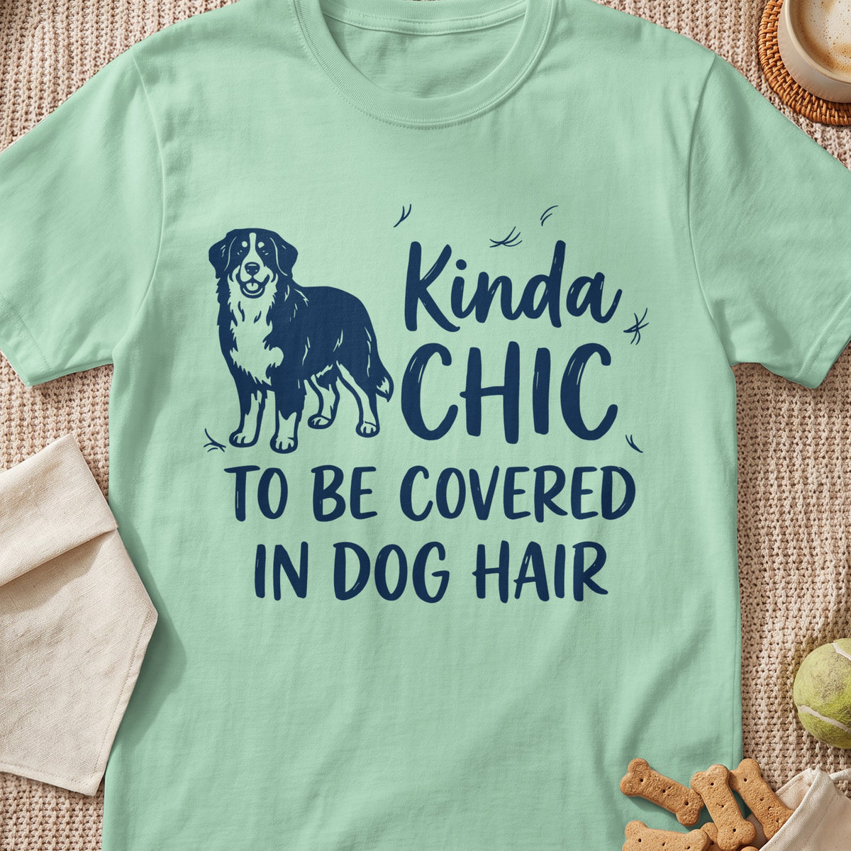 Light green t-shirt with navy blue text and dog graphic that reads "Kinda CHIC TO BE COVERED IN DOG HAIR".