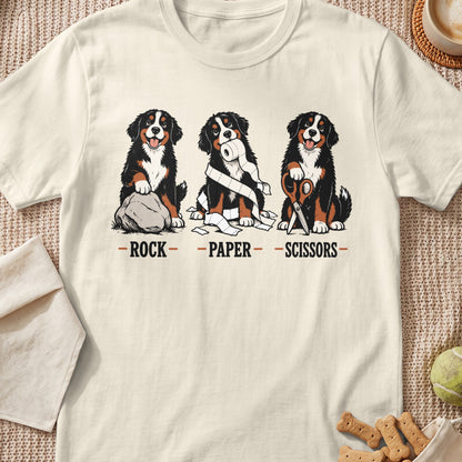Three Bernese Mountain Dogs play rock, paper, scissors with a rock, toilet paper, and scissors.