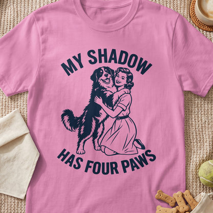 Pink t-shirt with woman hugging dog and text "MY SHADOW HAS FOUR PAWS".