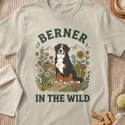Bernese Mountain Dog sitting in flowers with text "BERNER IN THE WILD"
