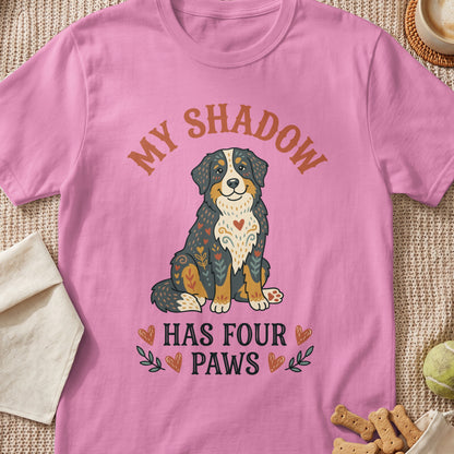 Pink t-shirt with a Bernese Mountain Dog graphic and text "MY SHADOW HAS FOUR PAWS".