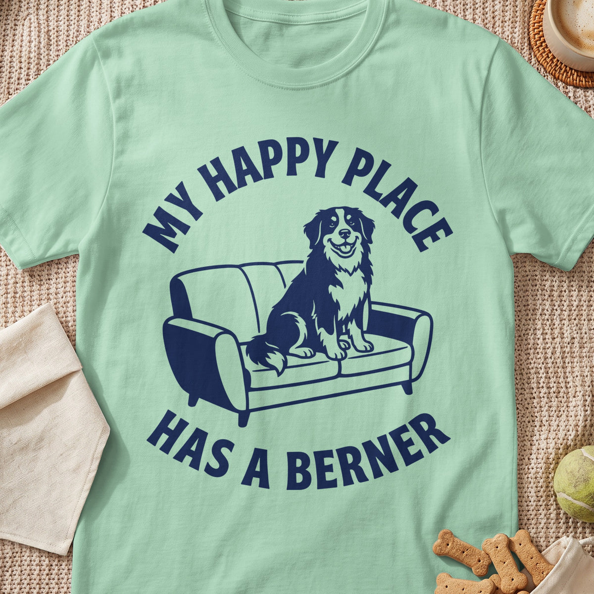 Mint t-shirt with navy blue text "MY HAPPY PLACE HAS A BERNER" and dog on couch graphic.