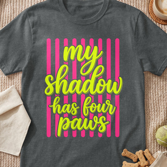 Dark gray t-shirt with yellow text reading my shadow has four paws over pink vertical stripes.