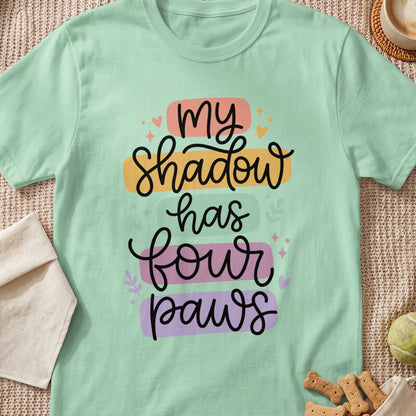 Mint green t-shirt with text "my Shadow has four paws" in script font.