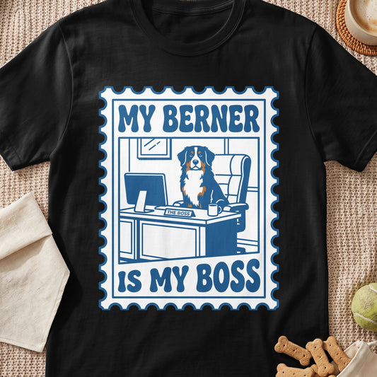 Bernese Mountain Dog sitting at a desk that says "The Boss" on a t-shirt.