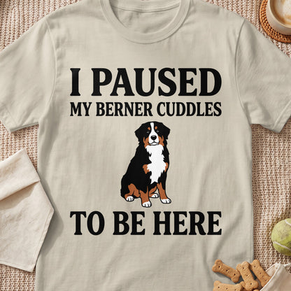 Light beige t-shirt with black text "I PAUSED MY BERNER CUDDLES TO BE HERE" and a Bernese Mountain Dog illustration.