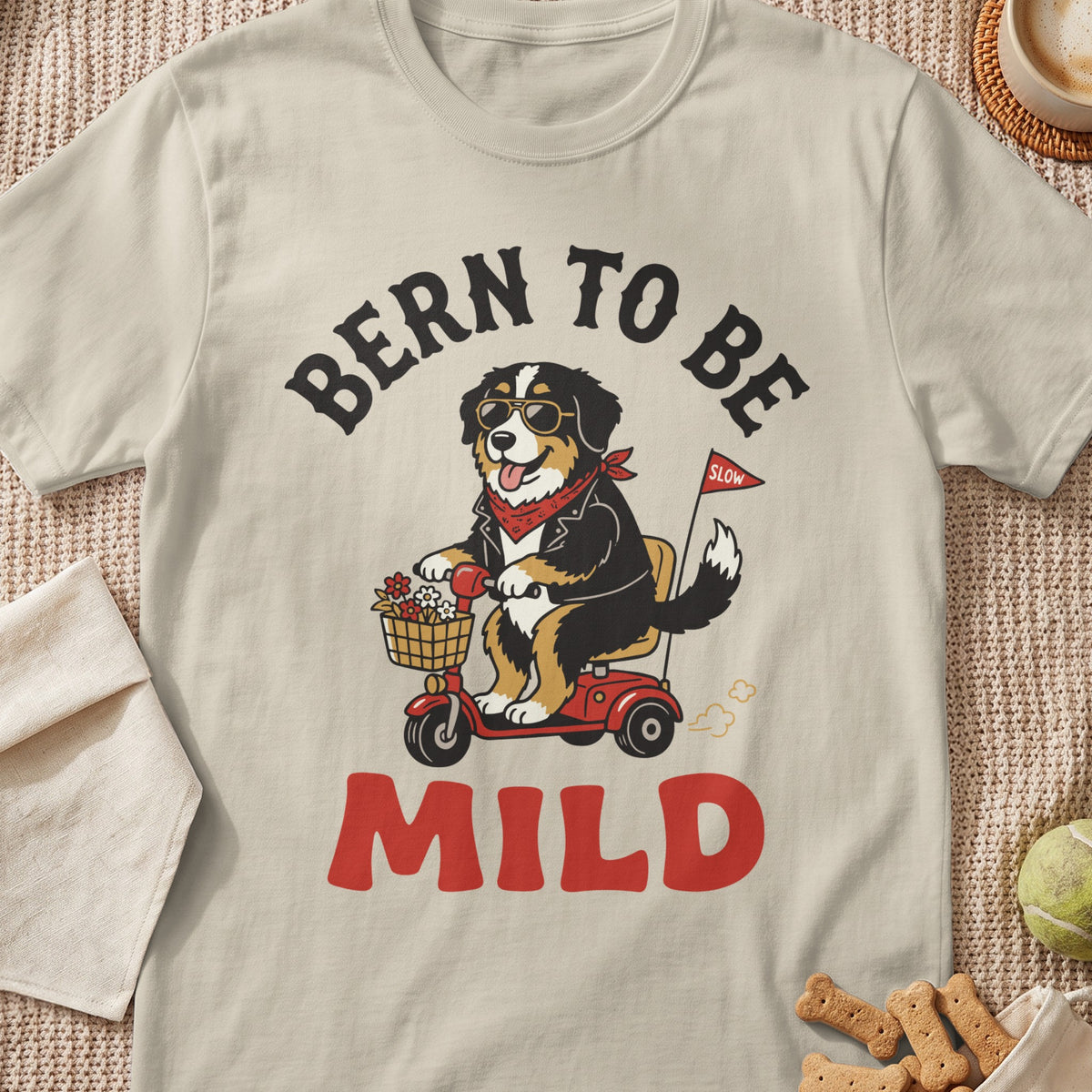 Bernese Mountain Dog on scooter with "Bern to be Mild" text and red flag.