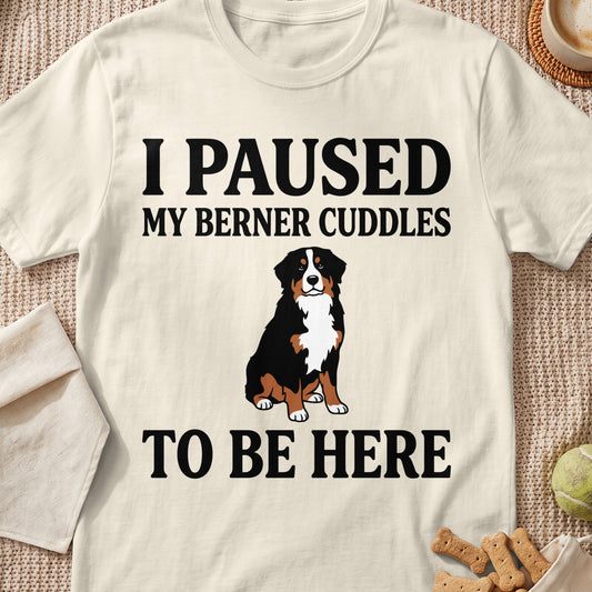 Bernese Mountain Dog sitting on a cream t-shirt with text "I PAUSED MY BERNER CUDDLES TO BE HERE".