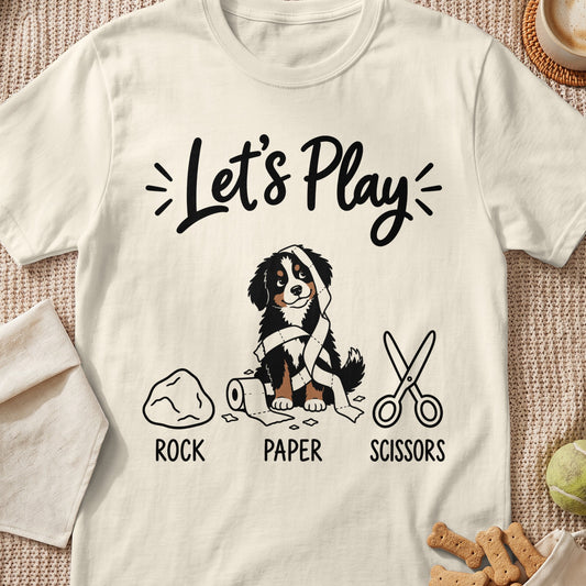 Bernese Mountain Dog tangled in paper with rock, paper, scissors text.