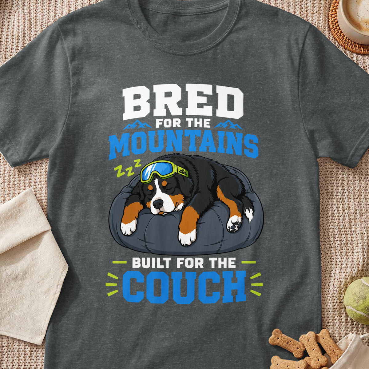 Bernese Mountain Dog sleeping on a pillow wearing goggles, "Bred for the Mountains, Built for the Couch" text.