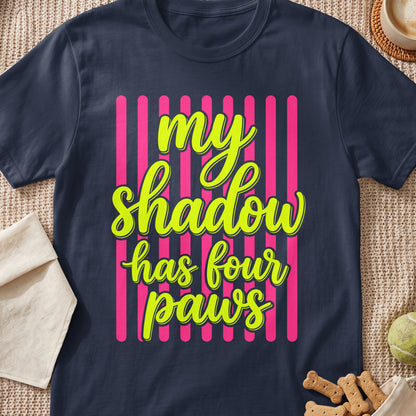 Dark t-shirt with neon green text "my shadow has four paws" on pink stripes.