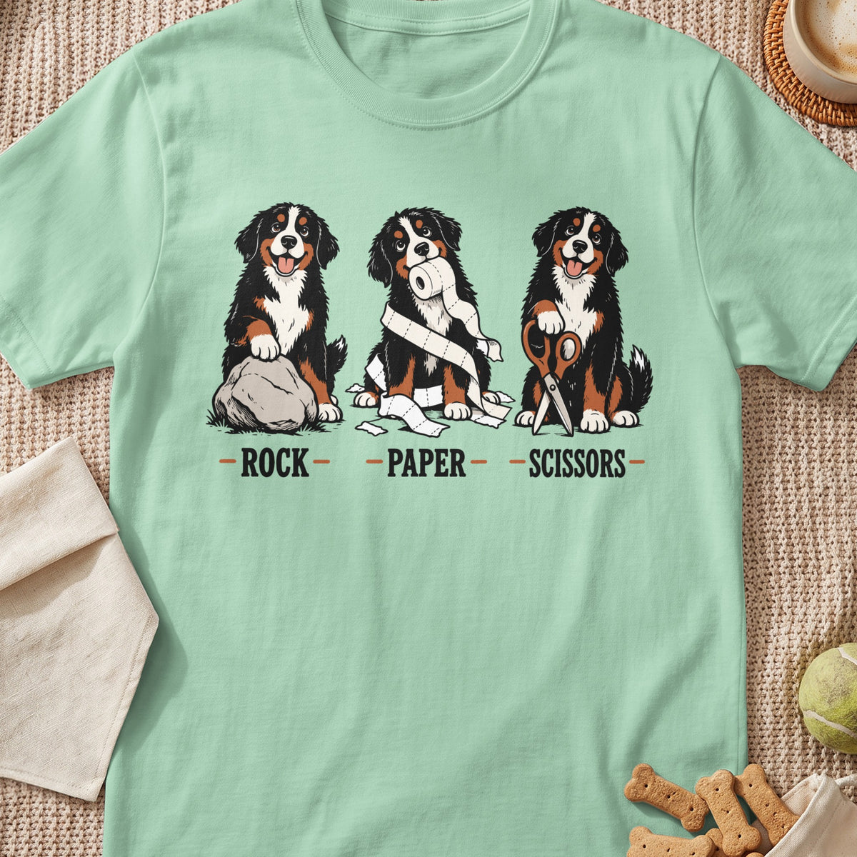 Three Bernese Mountain Dogs playing rock paper scissors with a rock, toilet paper, and scissors.