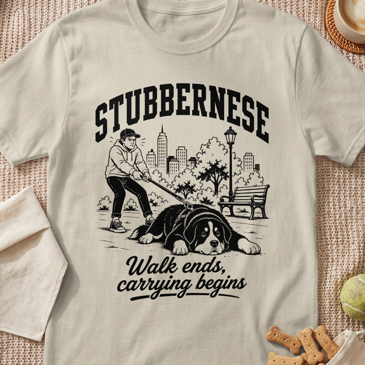 T-shirt graphic: "STUBBERNESE" text with man struggling to walk large dog in park.