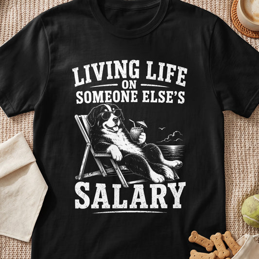Bernese Mountain Dog in lounge chair with drink, text "Living Life On Someone Else's Salary".