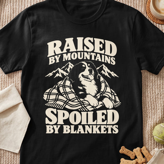 Black t-shirt with text "Raised by Mountains Spoiled by Blankets" and a dog.