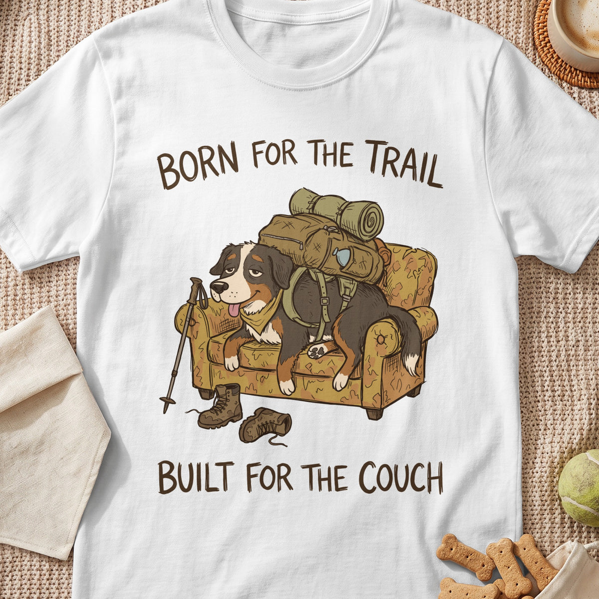 Bernese mountain dog with backpack resting on couch with text "Born for the Trail, Built for the Couch."