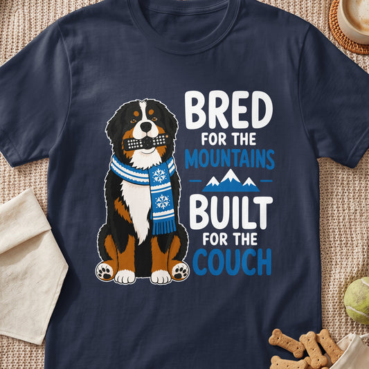 Bernese Mountain Dog with remote in mouth and scarf, text "Bred for the mountains built for the couch".
