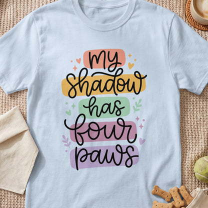 Light blue t-shirt with "My Shadow Has Four Paws" text in colorful blocks.