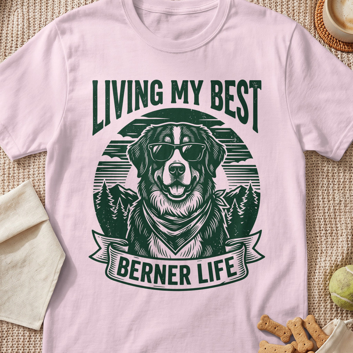 Pink t-shirt with a green graphic of a dog in sunglasses saying "LIVING MY BEST BERNER LIFE".