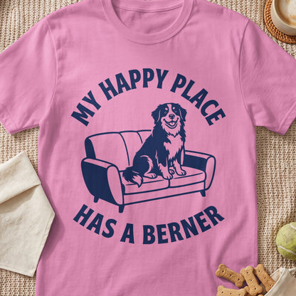 Pink t-shirt with navy blue text "MY HAPPY PLACE HAS A BERNER" and a dog on a couch graphic.