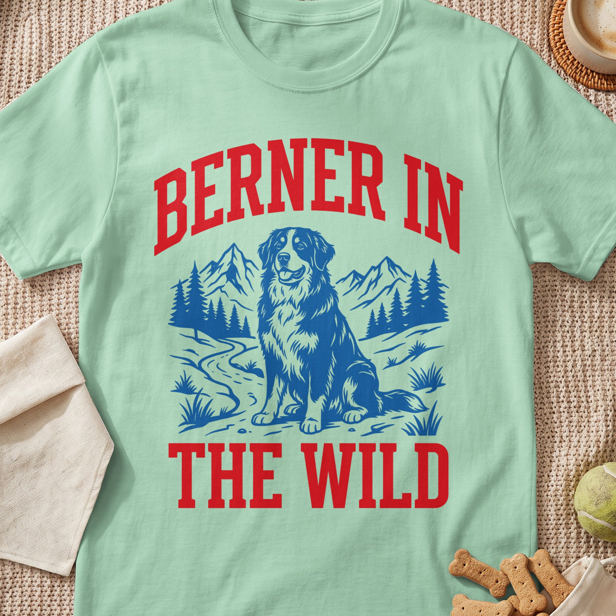 Berner in the Wild graphic on a light green t-shirt with a dog and mountains.