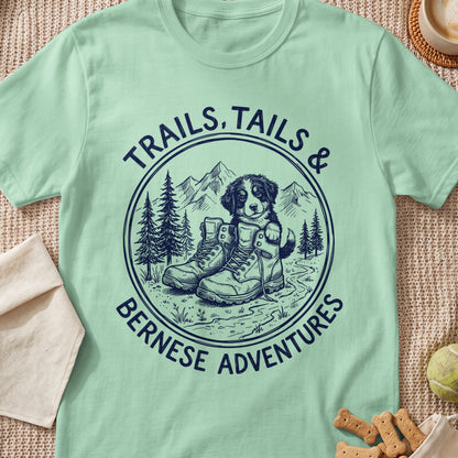 Bernese puppy peeking out of hiking boots with text "TRAILS, TAILS & BERNESE ADVENTURES".