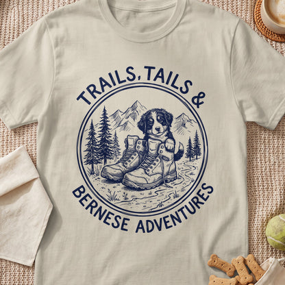 Bernese Mountain Dog puppy in boots with "Trails, Tails & Bernese Adventures" text.